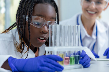 Females professional in clinic working with test tube conducting experiment on virus samples