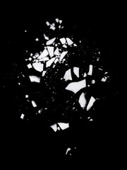 Debris or fragments of white porcelain isolated on black. White glass explosion on black background.