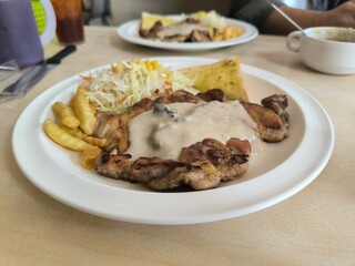 Chicken Steak with Mushroom Cream Sauce french fried and salad delicious food in Thai restuarant