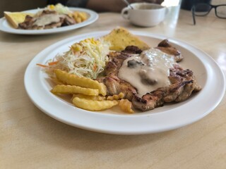 Chicken Steak with Mushroom Cream Sauce french fried and salad delicious food in Thai restuarant