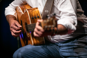 Man playing a guitar on stage (shallow DOF; color toned image)