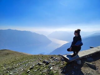 Fototapeta premium Overlooking the serene, expansive lake, a contemplative pretty girl finds solace and inspiration in the tranquil beauty of the surrounding landscape. 