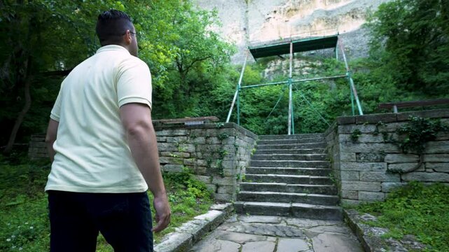 A tourist walks up the stairs towards the rock face of the Madara Plateau, where an ancient medieval rock relief called the Madara Rider can be found in Bulgaria.