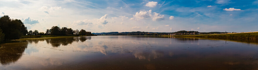 Fototapeta premium High resolution stitched autumn or indian summer panorama with reflections at Lake Vilstalsee, Reisbach, Marklkofen, Dingolfing-Landau, Bavaria, Germany