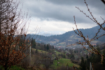 Scenic Mountain Valley with Village in Spring Under Dark Clouds