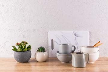 Eco-friendly kitchen, no waste concept of the house. Ceramic dishes, indoor plants on a wooden countertop. Front view.