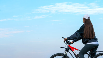 girl on a bicycle against the sky