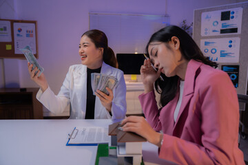 Real estate agent showing house model and dollar banknotes to stressed customer in office meeting at night, discussing a mortgage or rent, investment or financial problems