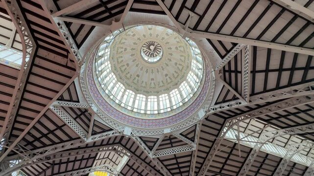 Interior view of Valencia&rsquo;s Mercat Central, showcasing architectural details, intricate ceiling design, and vibrant market atmosphere. Ideal for travel, architecture, and cultural projects.