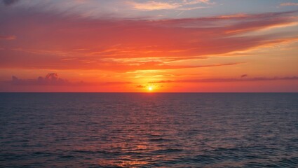 Obraz premium Serene Sunset over the Ocean with Vibrant Orange and Pink Skies Reflecting on Calm Waters in the Evening Light