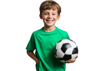 A young boy in a green soccer jersey is smiling and holding a black and white soccer ball against a transparent background