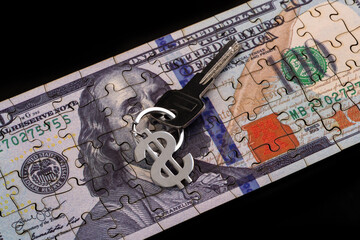 An apartment key with a keychain in the form of an American dollar symbol against a background of...