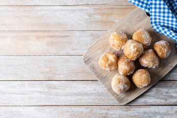 Traditional Carnival fritters or buñuelos de viento on wooden table. Top view. Copy space