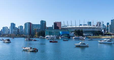 Vancouver, BC, Canada - April 16 2021 : Vancouver marina, False Creek, modern buildings skyline in the background. BC Place.