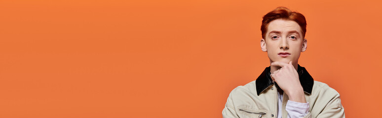 Capturing the thoughts of a young handsome man against a vibrant orange backdrop of emotion