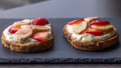 delicious toast with creamy ricotta, strawberries, and bananas close-up