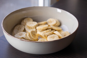 fresh banana slices in a white bowl close-up