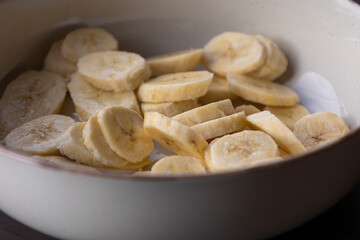 fresh banana slices in a white bowl close-up