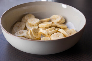 fresh banana slices in a white bowl close-up
