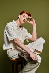 Emotional expression captured in a stylish indoor setting with a young handsome man