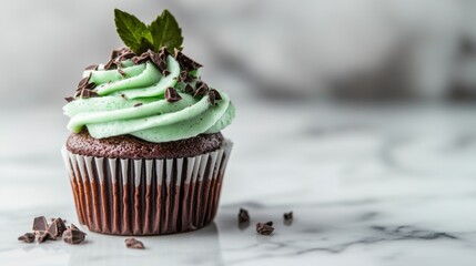 Delicious mint chocolate cupcake with a fluffy green frosting garnished with chocolate shavings, served on a sleek marble background to highlight its tempting design