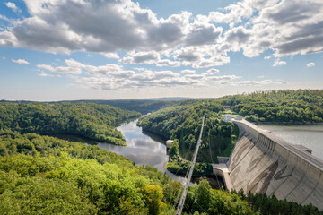 Rappbode Valley, Germany  – August 26, 2024: Tourists visit the Titan RT Suspension bridge and Rappbode Dam (Harz Mountains, Saxony). The bridge spans the river Bode in the middle of the valley
