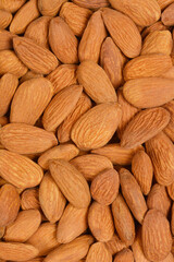 A close-up, top-down shot of a pile of raw almonds, showcasing their natural texture and color.