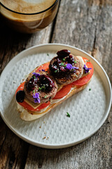 homemade toast with mayonnaise, tomato, tofu, bean cutlets, sun-dried plums, sesame, rosemary and violets
