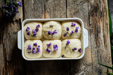 apricot buns with viola. Top view, wooden background. flower decoration