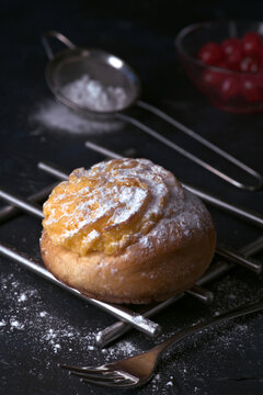 Freshly baked cream bun dusted with icing sugar