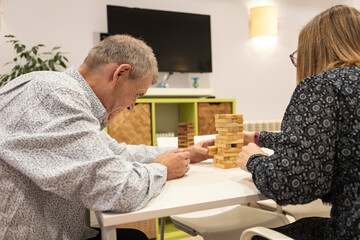 Couple with intellectual disabilities enjoy a game in supervised home