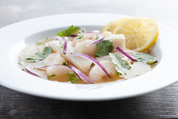 Traditional Peruvian ceviche sea bass fillet on wooden table