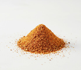 A small mound of Cajun seasoning, with a few scattered granules around it, placed on a clean white surface for a minimalistic look