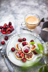 Cottage cheese pancakes with fresh cherry and coffee for breakfast