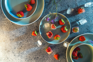 Fresh strawberries and ice cubes on plates for a refreshing summer dessert