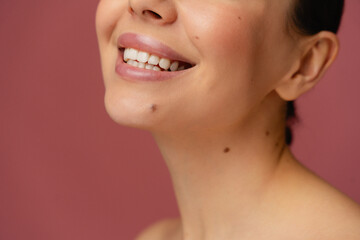 The image features a close-up of a smiling face with smooth skin and a bright, cheerful appearance....