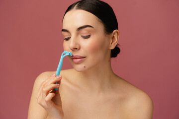 A carefully groomed adult demonstrating the hygiene and beauty process of shaving facial hair.