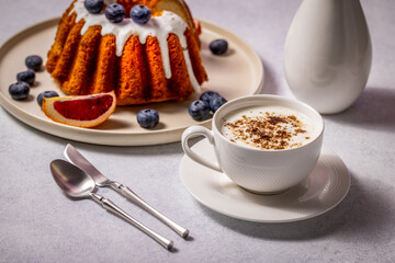 Delicious gugelhupf cake with blueberries, blood orange, and cappuccino for perfect breakfast