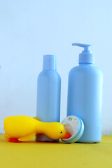 Photo of skin care products on a yellow and white background. With a bright rubber duck.