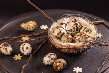 Quail eggs nest with spring decorations symbolizing new life