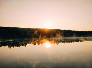 A foggy lake surrounded by a forest at sunrise in Karelia. An abandoned marble quarry.