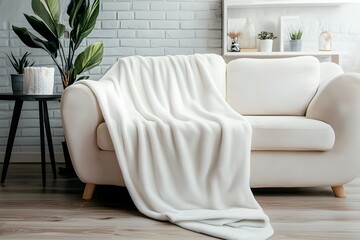 Cozy Comfort: A soft, pristine blanket drapes invitingly over a comfortable cream-colored sofa, creating a scene of home relaxation.