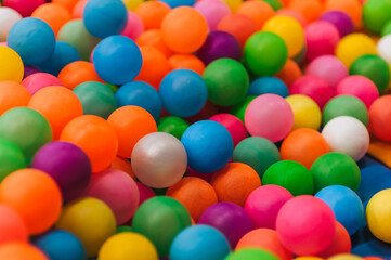 Background of many plastic colorful and multicolored round balls in children's playroom for kids to play. Photography, childhood concept, abstract.