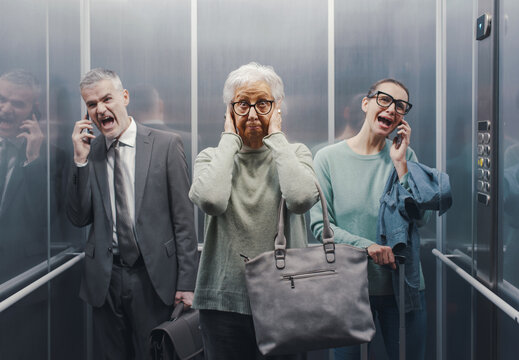 Senior lady irritated by people talking loudly on the phone