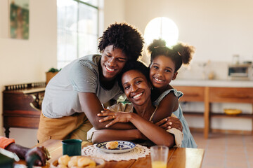 Kids hugging their mom at the breakfast table, thanking her for the delicious pão de queijo meal