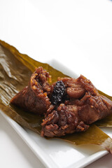 Traditional Chinese Glutinous Rice Dumpling (Bak Chang) Unwrapped on Plate isolated on white background