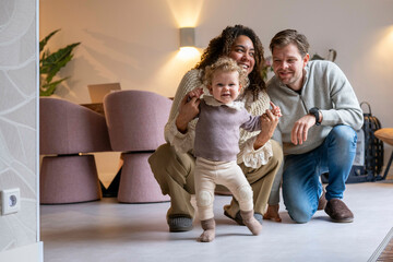Happy family indoors with toddler holding hands, smiling and enjoying their time together. Netherlands