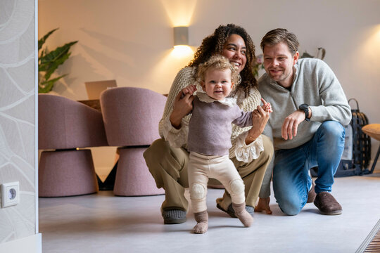 Happy family indoors with toddler holding hands, smiling and enjoying their time together. Netherlands