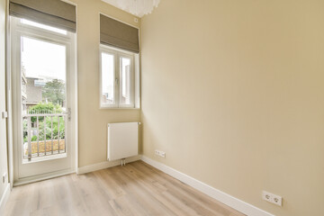 A well-lit, modern room showcasing large windows that connect indoor spaces to the outside greenery, featuring minimalistic design elements and natural light.