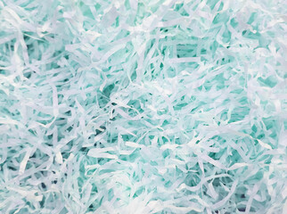 Shredded pastel blue paper texture, suitable for use in eco-friendly packaging, gift wrapping, and creative craft projects.